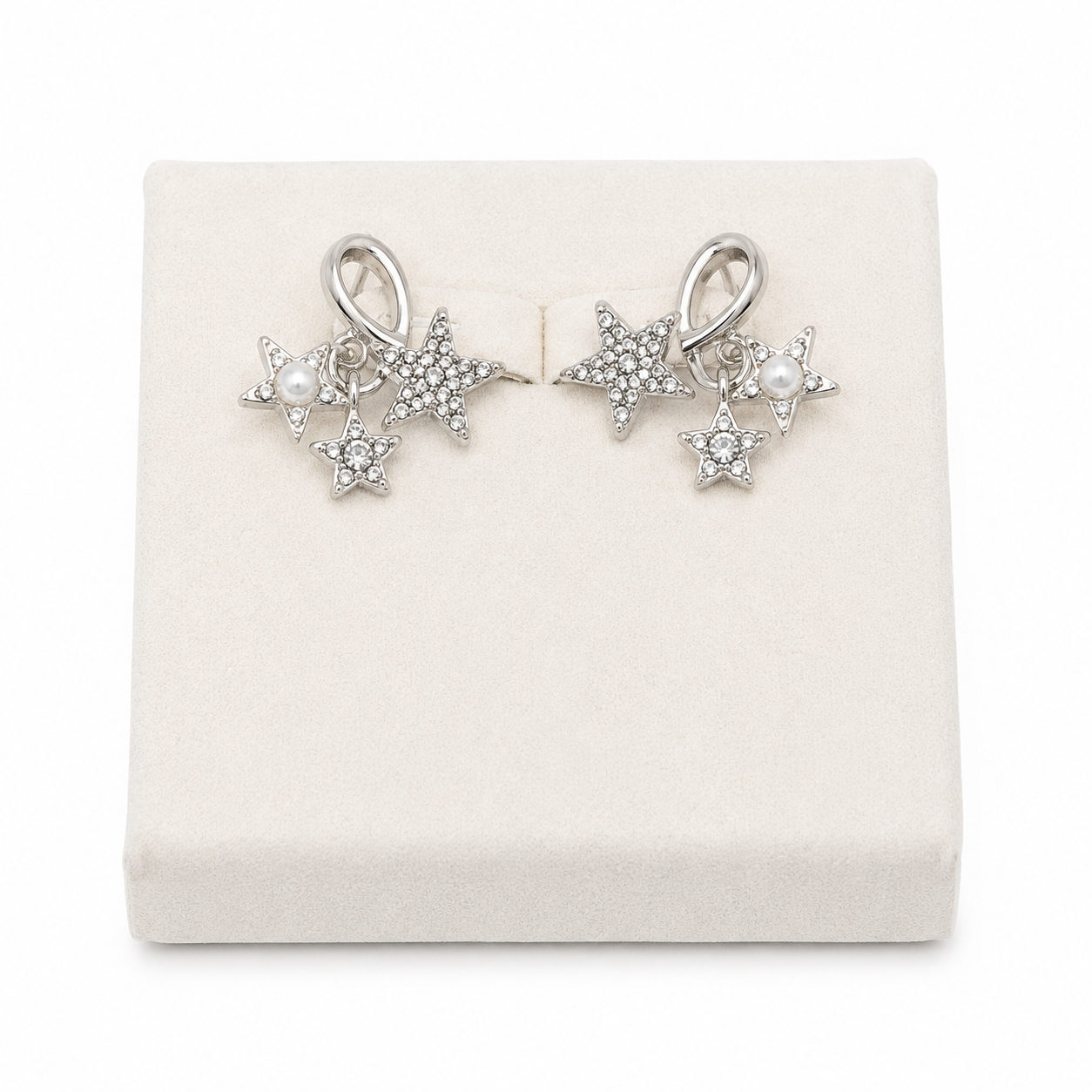 Aretes colgantes con diseño de estrellas plateadas y perlas decorativas.
