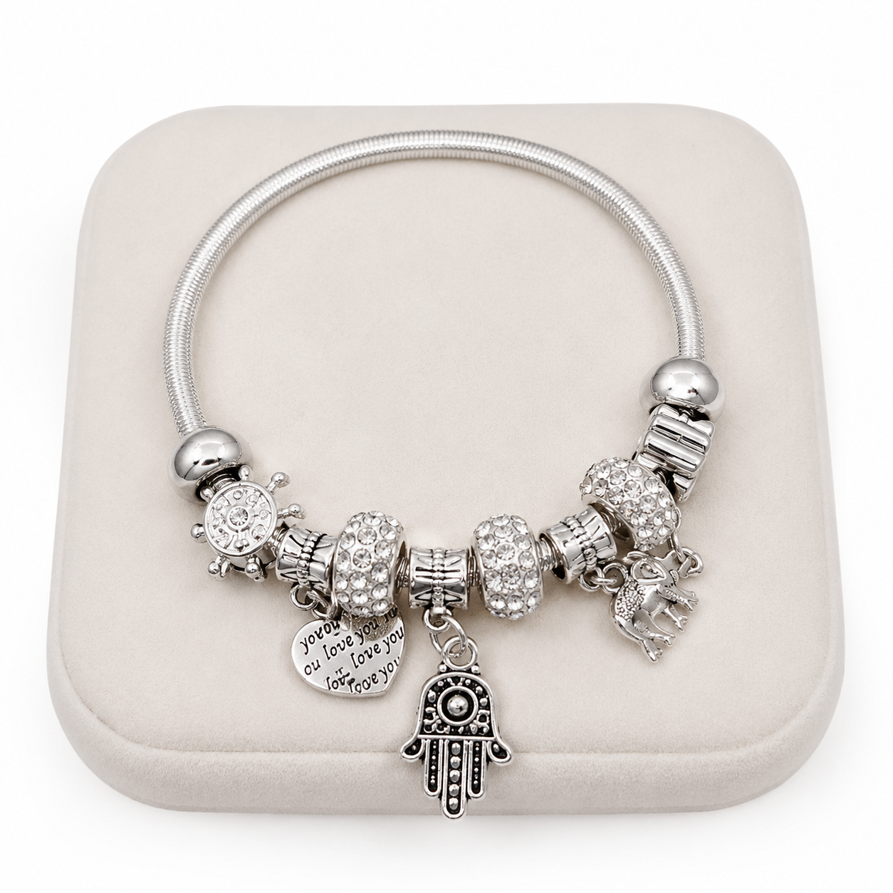 Pulsera con dijes decorativos y cristales en color plateado.
