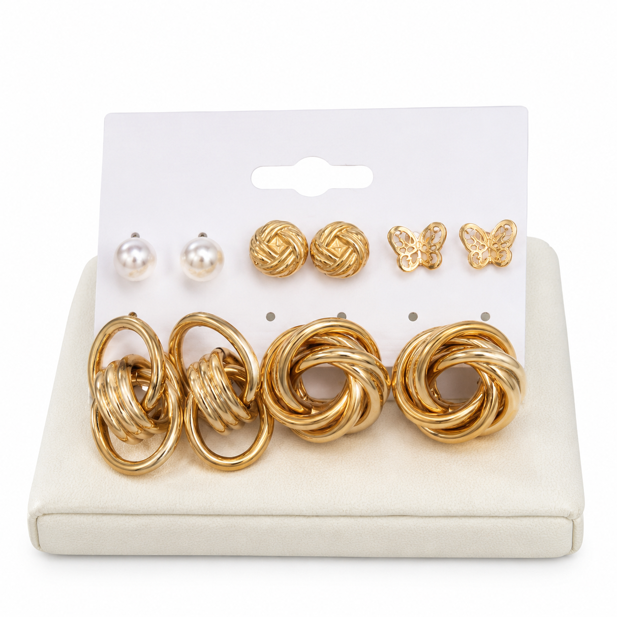 Set de aretes con diseños de nudo, mariposa y perla en color dorado y blanco.