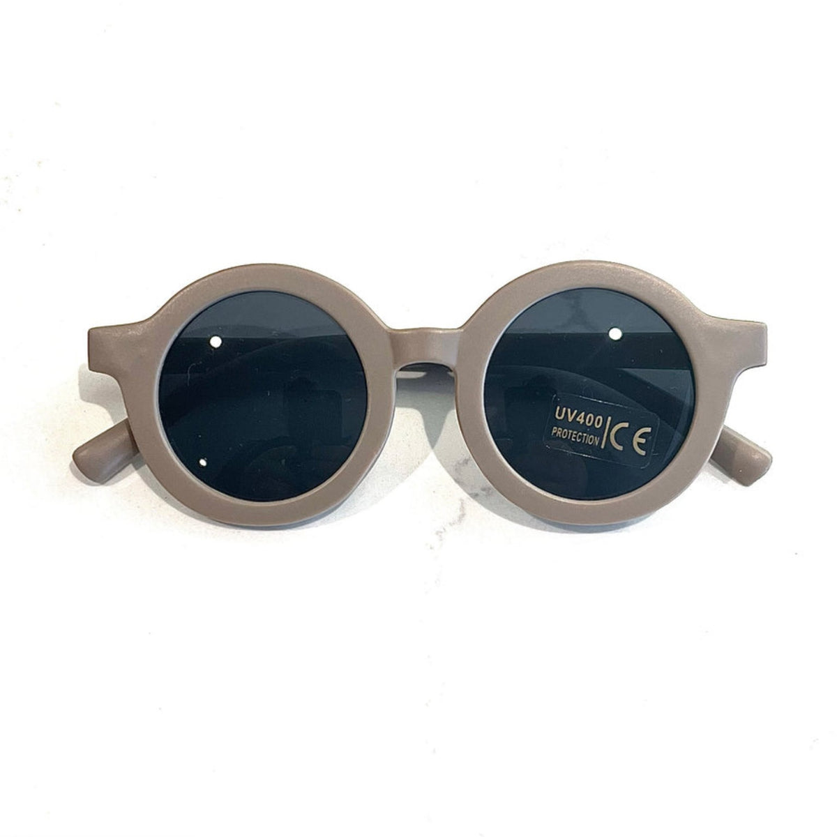 Gafas de sol redondas con montura beige y lentes oscuros con protección UV400.
