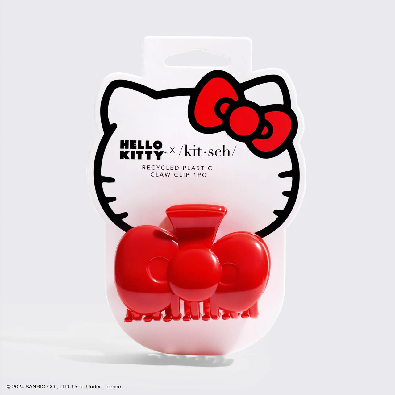 Pinza para el cabello con forma de lazo rojo, hecha de plástico reciclado.