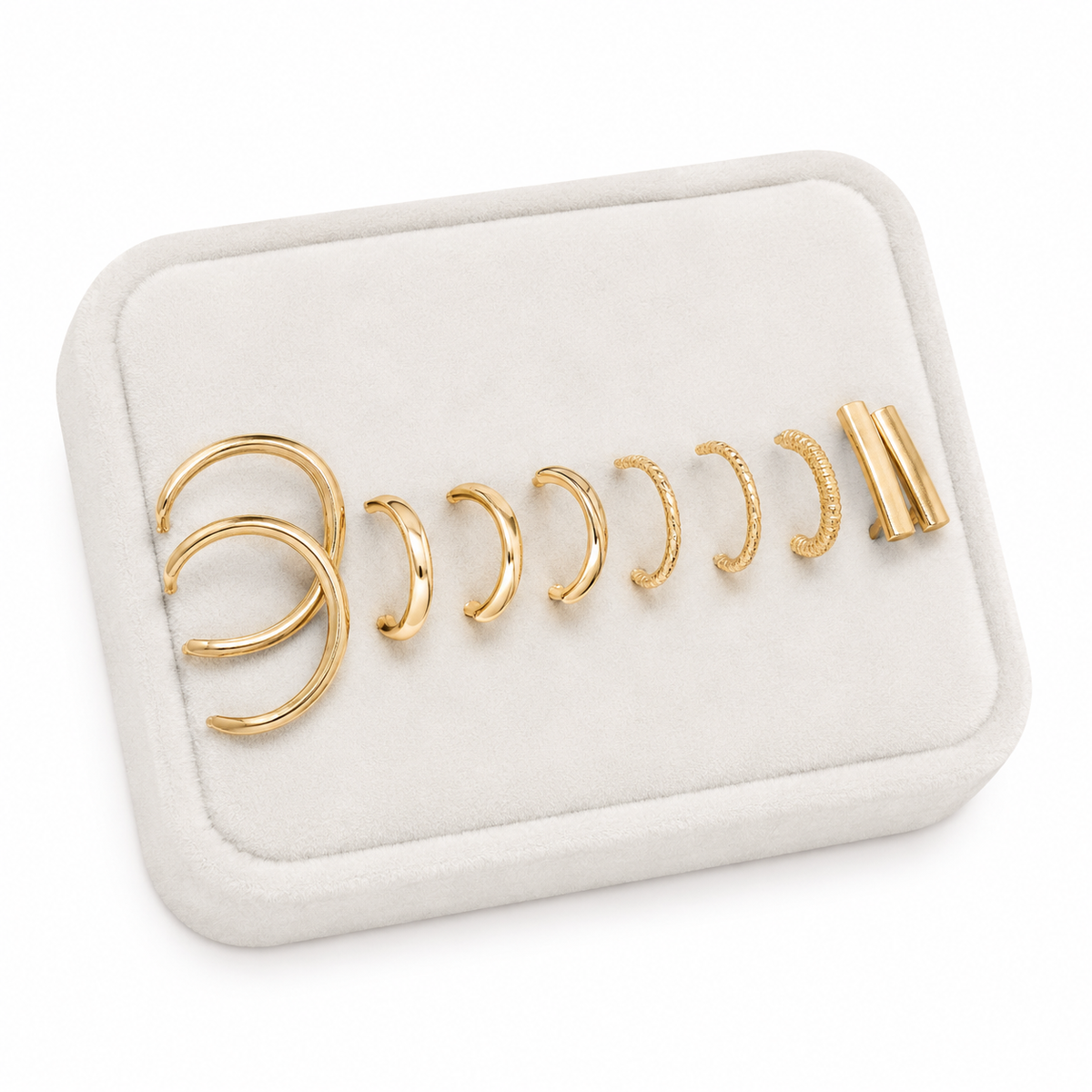 Set de aretes y ear cuffs dorados con diseños variados.