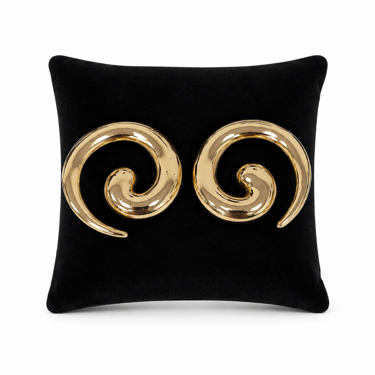 Aretes grandes dorados con diseño de espiral abierta.