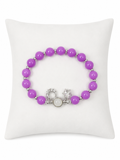 Pulsera elástica de cuentas color lavanda con detalles plateados y dije decorativo.