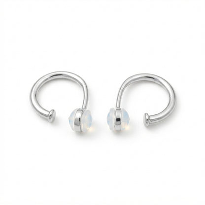 Aretes abiertos de diseño curvo color plateado con extremos redondeados.