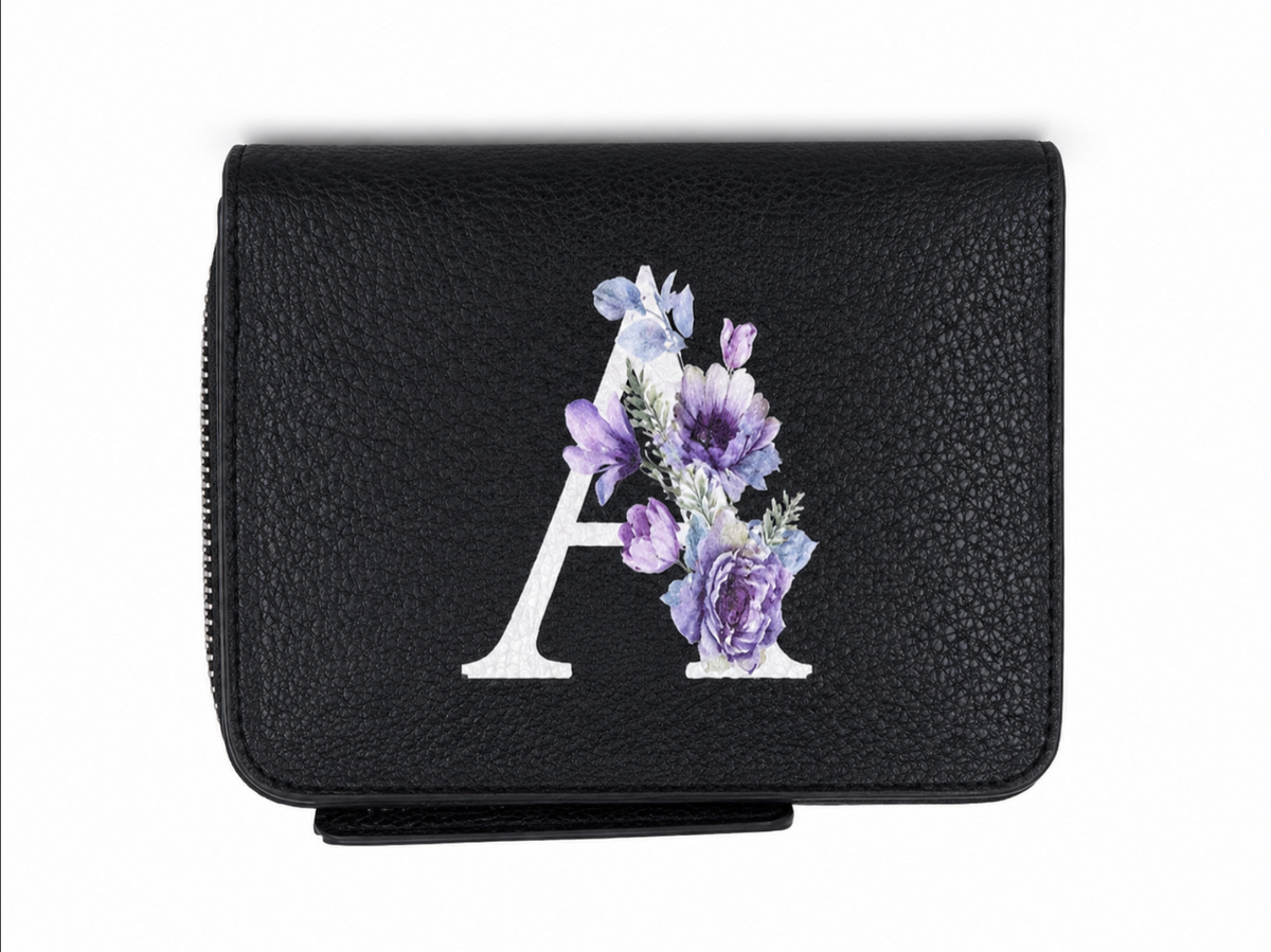 Billetera negra con cierre y diseño de letra A con estampado floral.