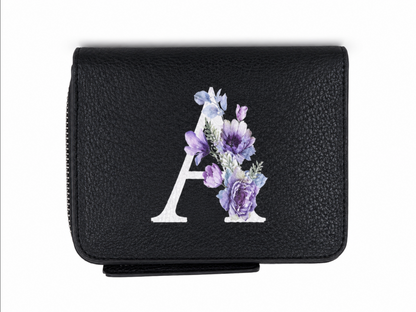 Billetera negra con cierre y diseño de letra A con estampado floral.