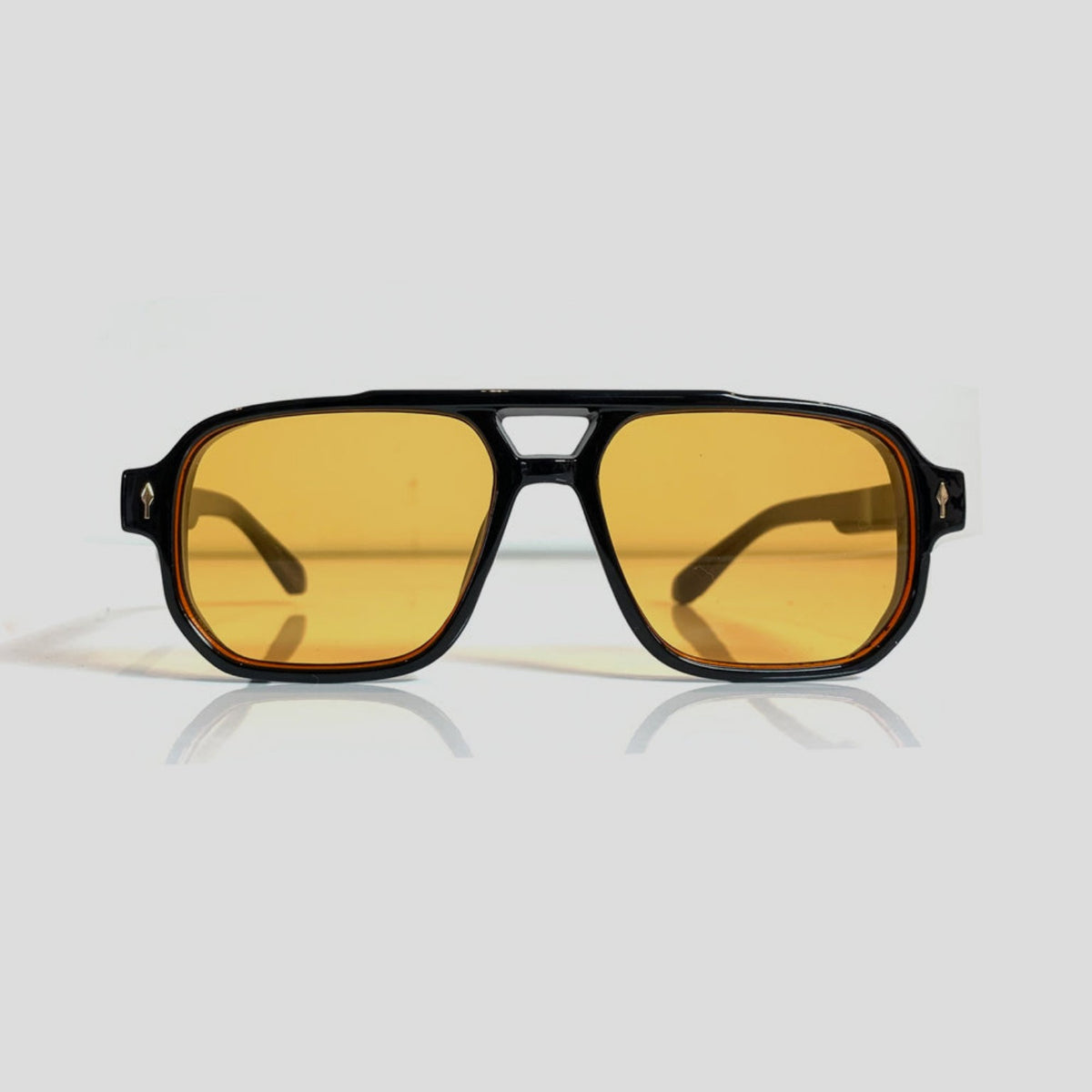 Gafas de sol estilo aviador con montura negra y lentes amarillos.