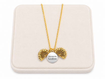 Collar con dije de girasol desplegable color dorado con medallón grabado.