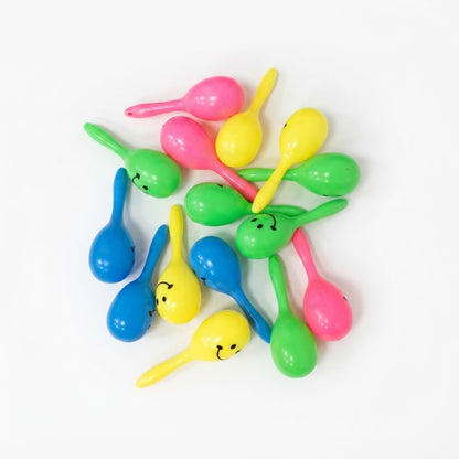 Mini maracas de plástico de colores surtidos con caritas felices utilizadas habitualmente como juguetes infantiles.