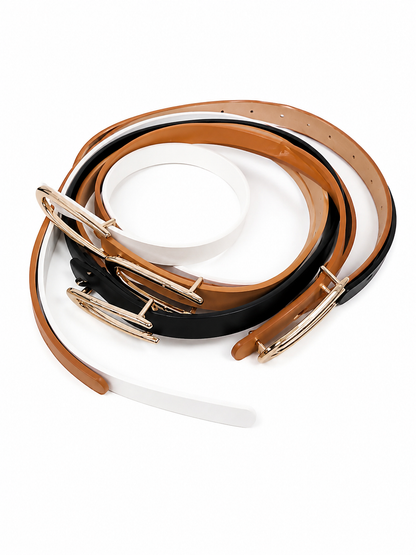Set de cinturones delgados para mujer con hebilla metálica en colores blanco, negro y camel.