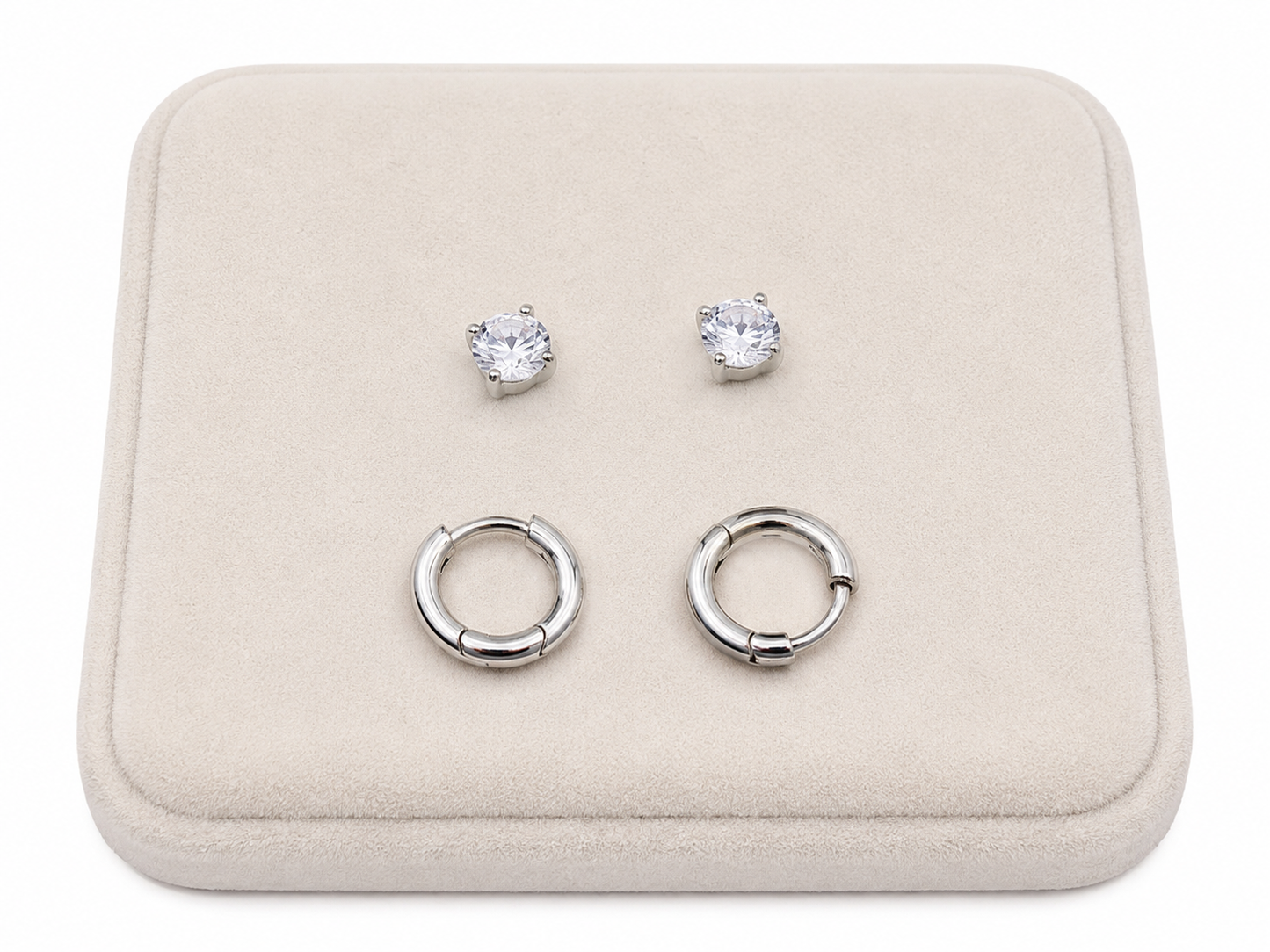 Set de aretes color plateado con argollas lisas y pendientes de piedra brillante.