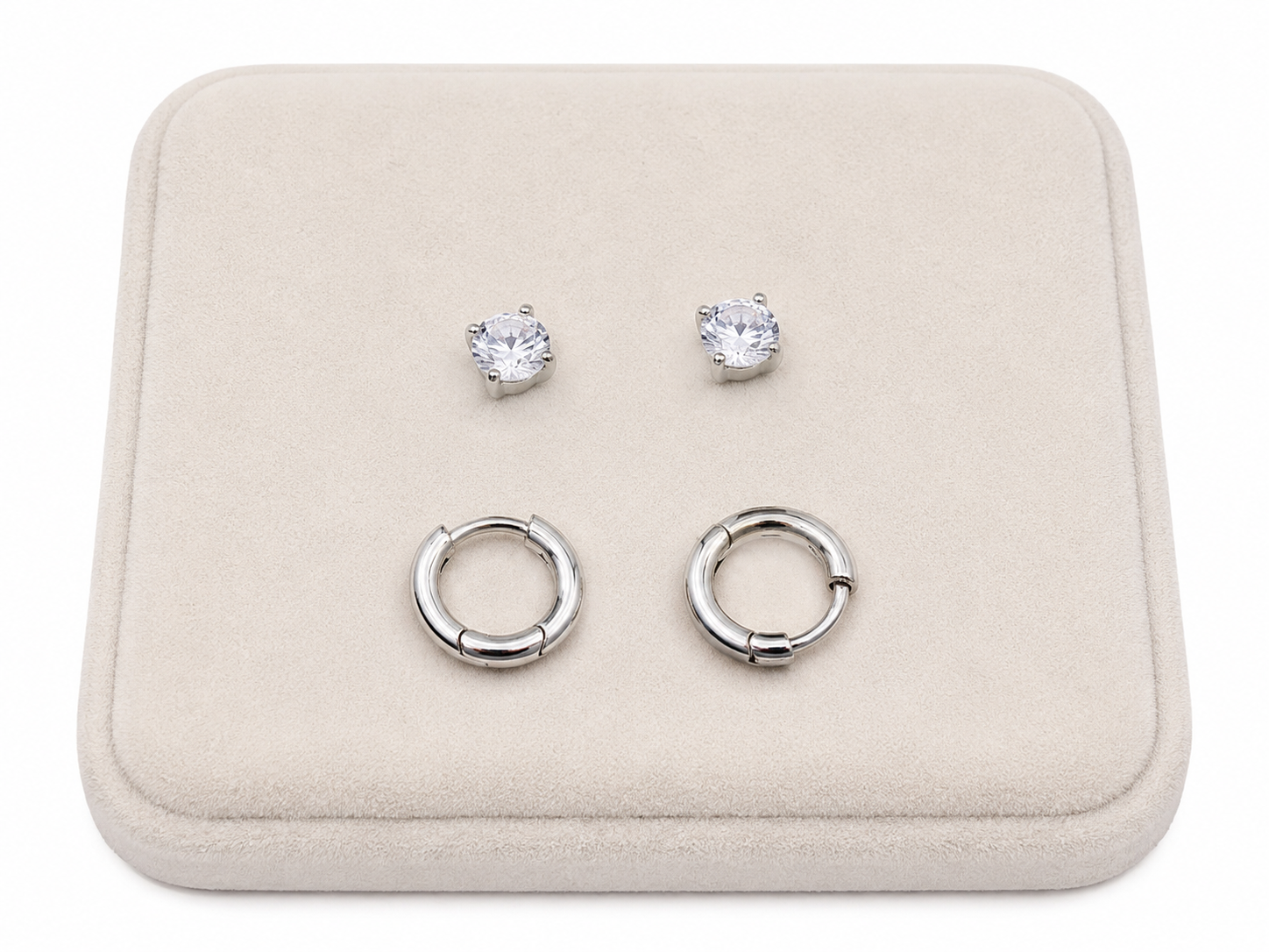 Set de aretes color plateado con argollas lisas y pendientes de piedra brillante.