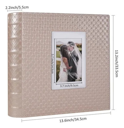 Álbum de fotos beige con portada texturizada y ventana para fotografía, 34.5 × 33.5 cm.