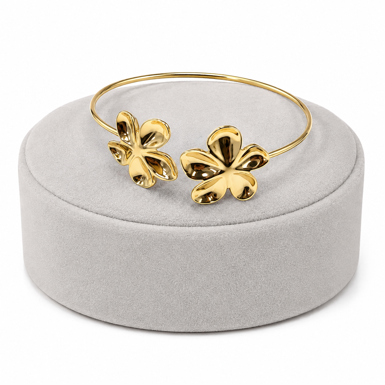 Pulsera dorada abierta con diseño de flores.