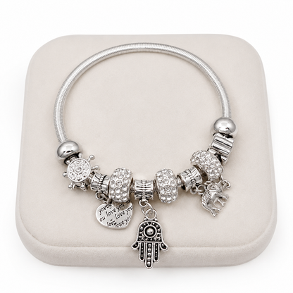 Pulsera con dijes decorativos y cristales en color plateado.
