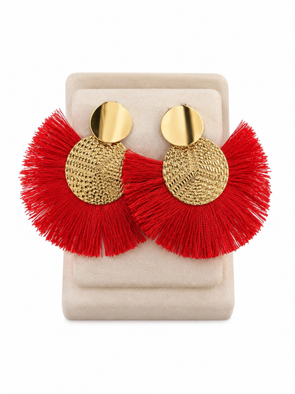 Aretes colgantes de flecos color rojo con diseño circular dorado.