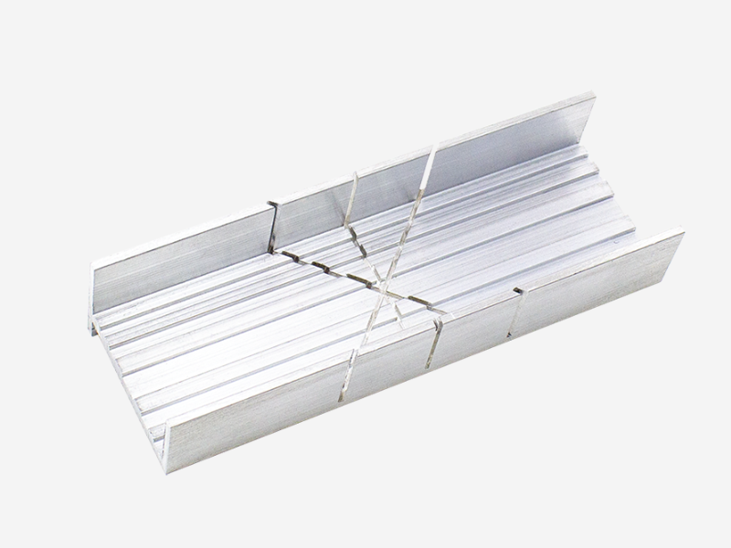 Caja de ingletes de aluminio utilizada para realizar cortes precisos en ángulos con sierras manuales.