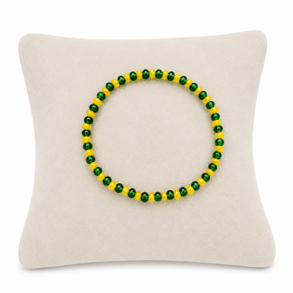 Pulsera elástica de cuentas verdes y amarillas con diseño bicolor.