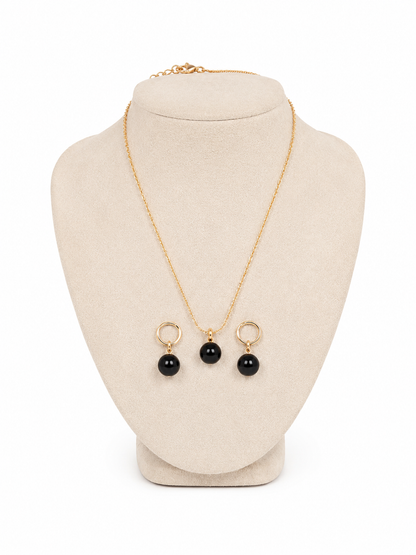 Juego de collar y aretes con colgantes redondos color negro.