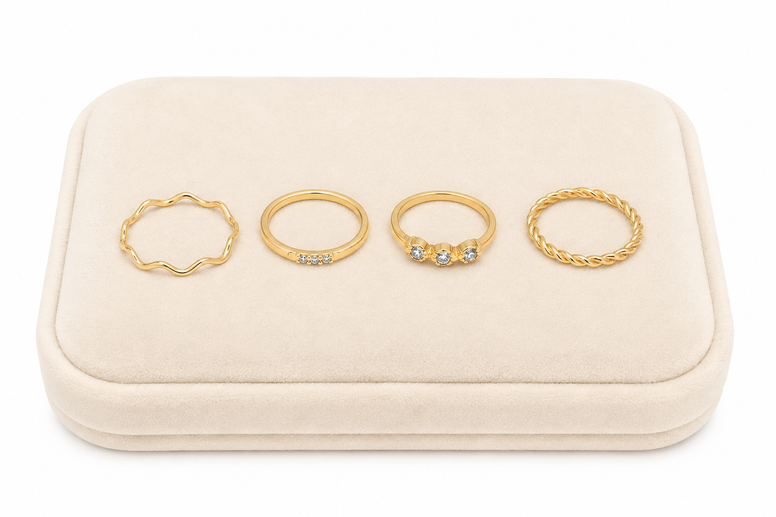 Set de 4 anillos dorados con diseños ondulados, trenzados y detalles brillantes.