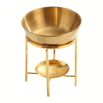 Quemador aromático dorado con recipiente superior y soporte elevado.