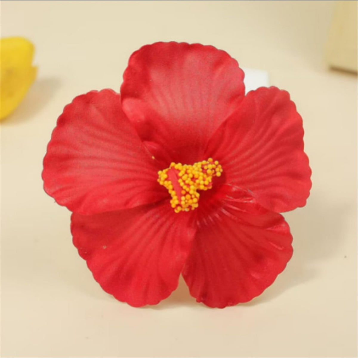 Flor artificial de hibisco rojo con centro amarillo para decoración.