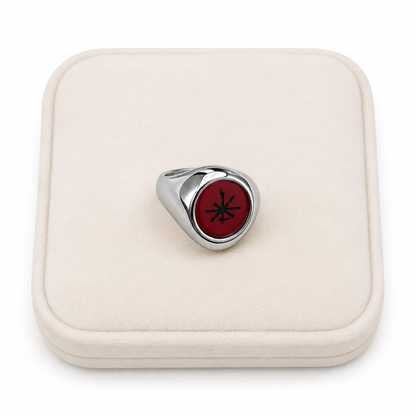 Anillo de diseño clásico con detalle circular rojo.