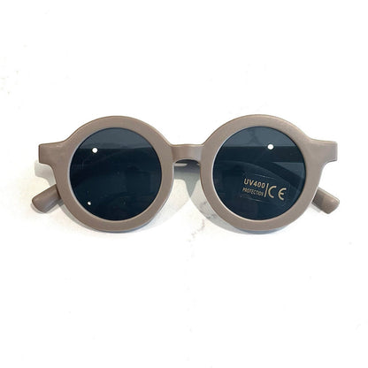 Gafas de sol redondas con montura beige y lentes oscuros con protección UV400.