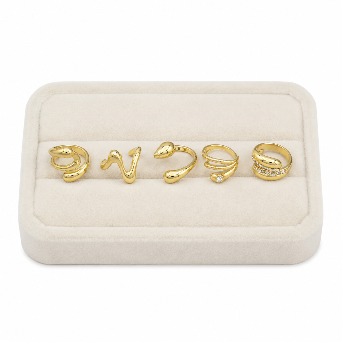 Set de 5 anillos dorados con diseños ondulados y piedras brillantes.