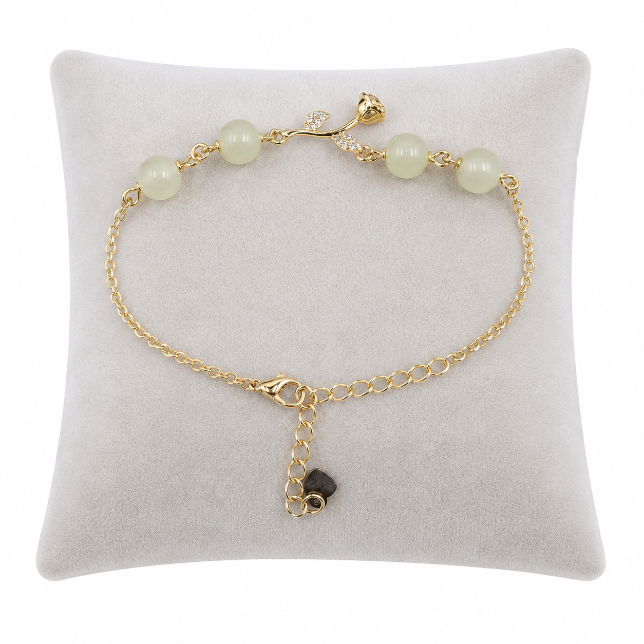 Pulsera de cadena dorada con cuentas verde claro y detalles florales.