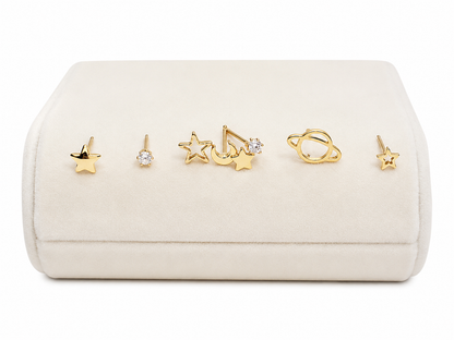 Set de aretes con diseño de estrellas, planeta y circonitas color dorado.