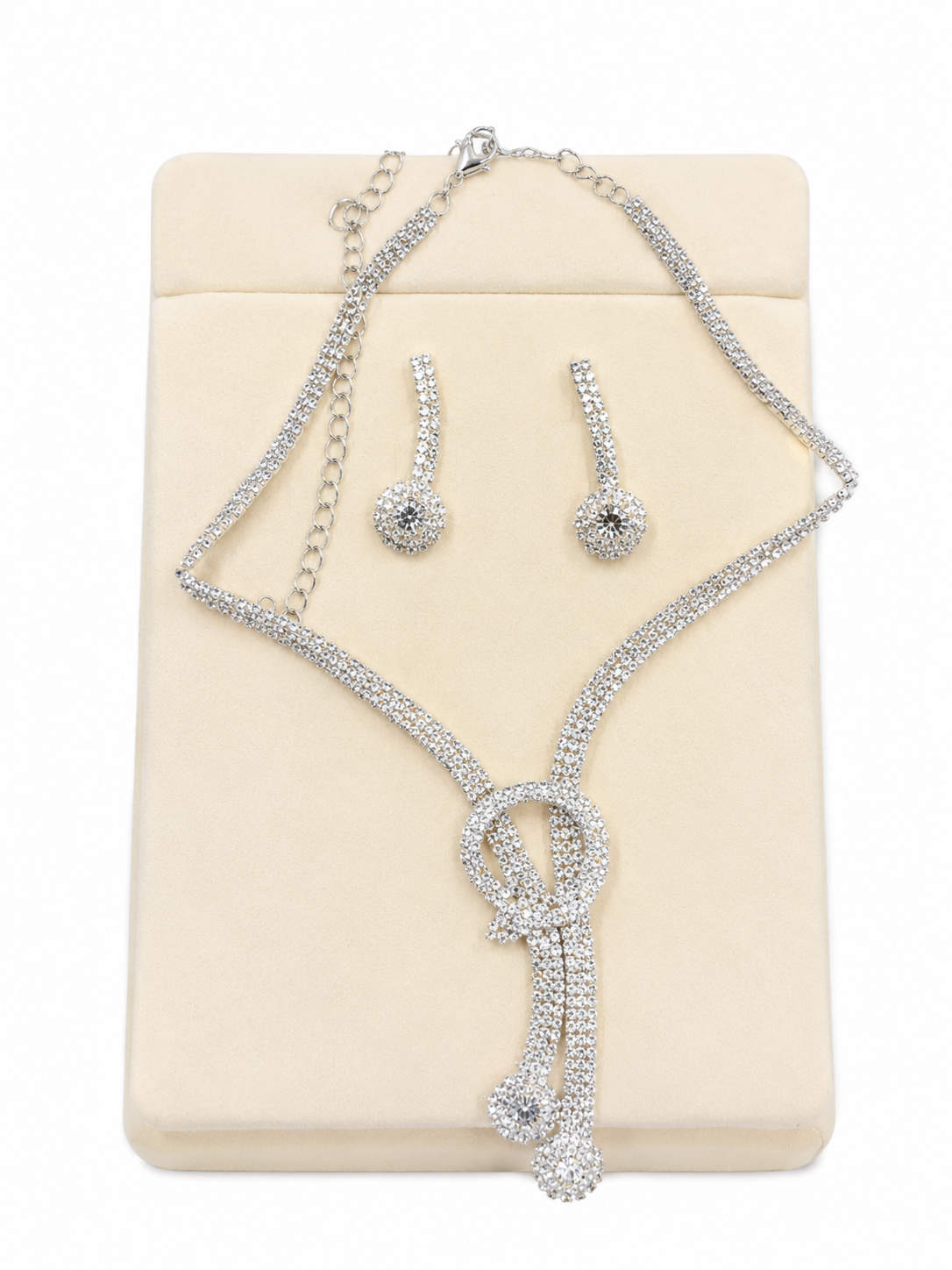 Conjunto de collar, pulsera y pendientes con diseño brillante color plateado.