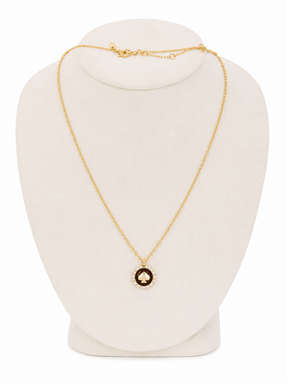 Collar con colgante circular de diseño elegante en color dorado y negro.