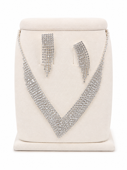 Conjunto de collar y aretes plateados con diseño de pedrería brillante y flecos.