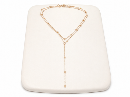 Collar Dorado de Doble Cadena con Detalles de Bolitas y Diseño Largo en Y.