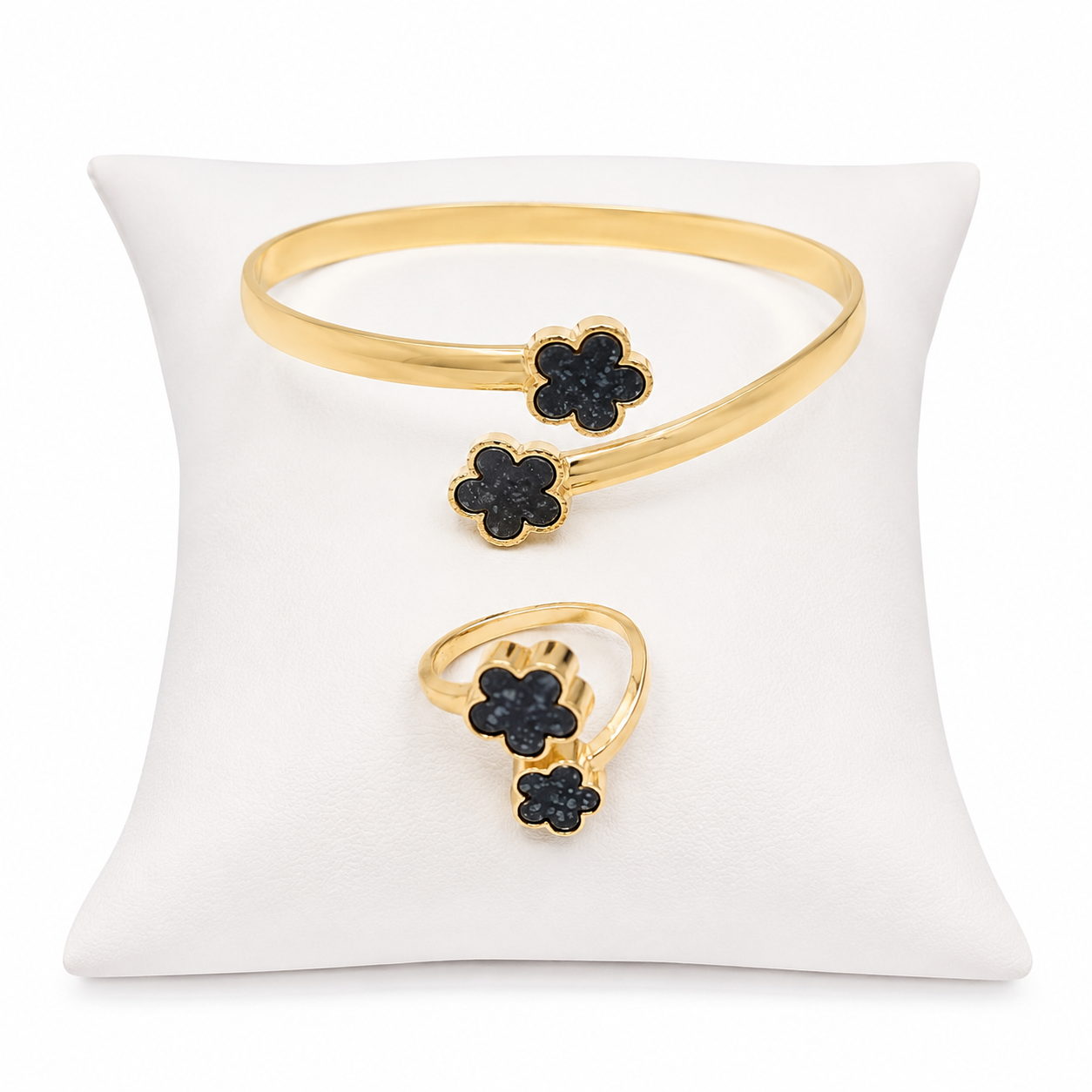 Conjunto de pulsera abierta y anillo ajustable con diseño de trébol color dorado.