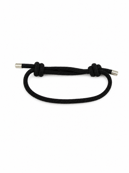 Pulsera Ajustable de Cuerda Negra con Nudos Decorativos y Terminales Metálicos.