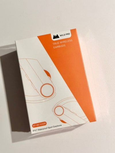 Audífonos inalámbricos con estuche de carga en color naranja y blanco.