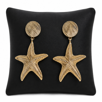 Aretes colgantes dorados con diseño de estrella de mar.