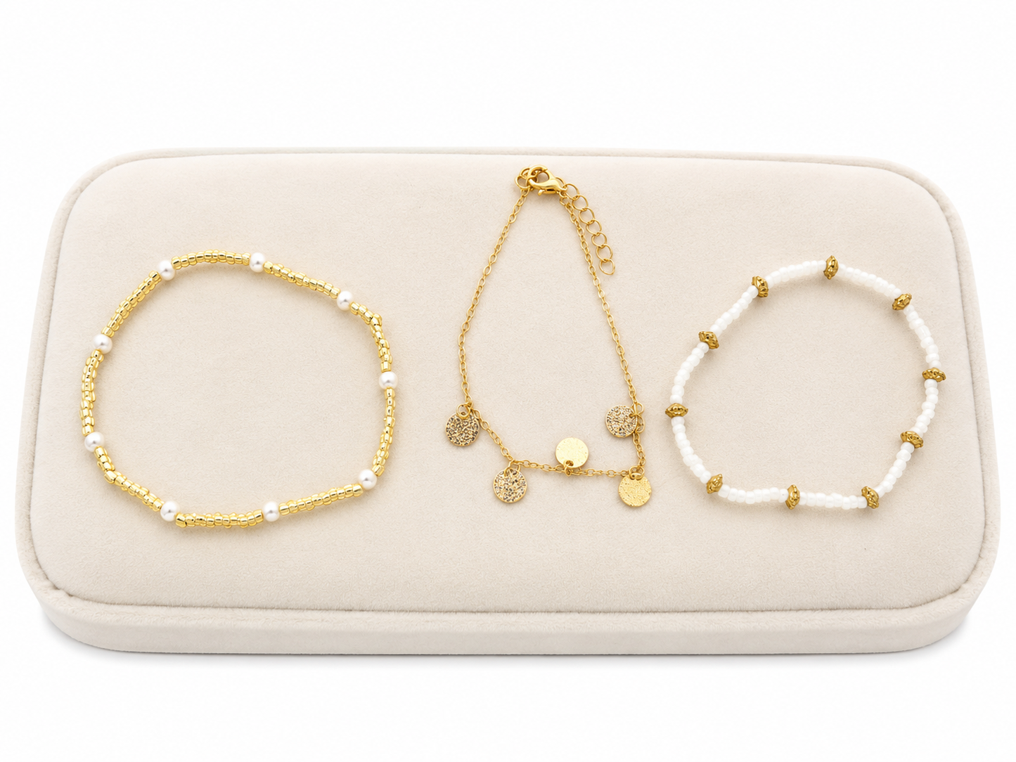 Set de 3 pulseras de diseño elegante en colores dorado y blanco.