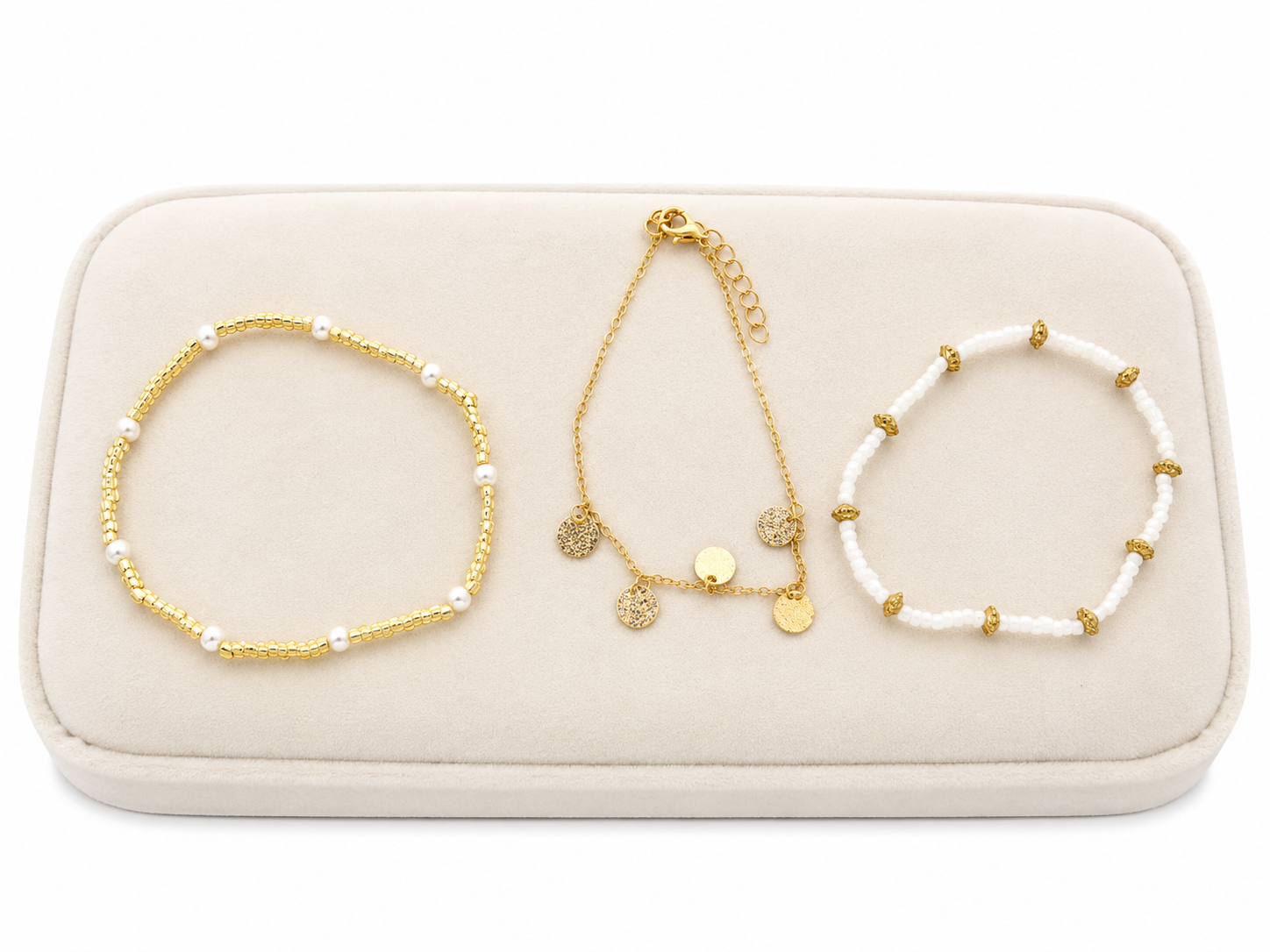 Set de 3 pulseras de diseño elegante en colores dorado y blanco.
