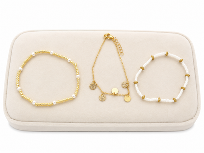 Set de 3 pulseras de diseño elegante en colores dorado y blanco.
