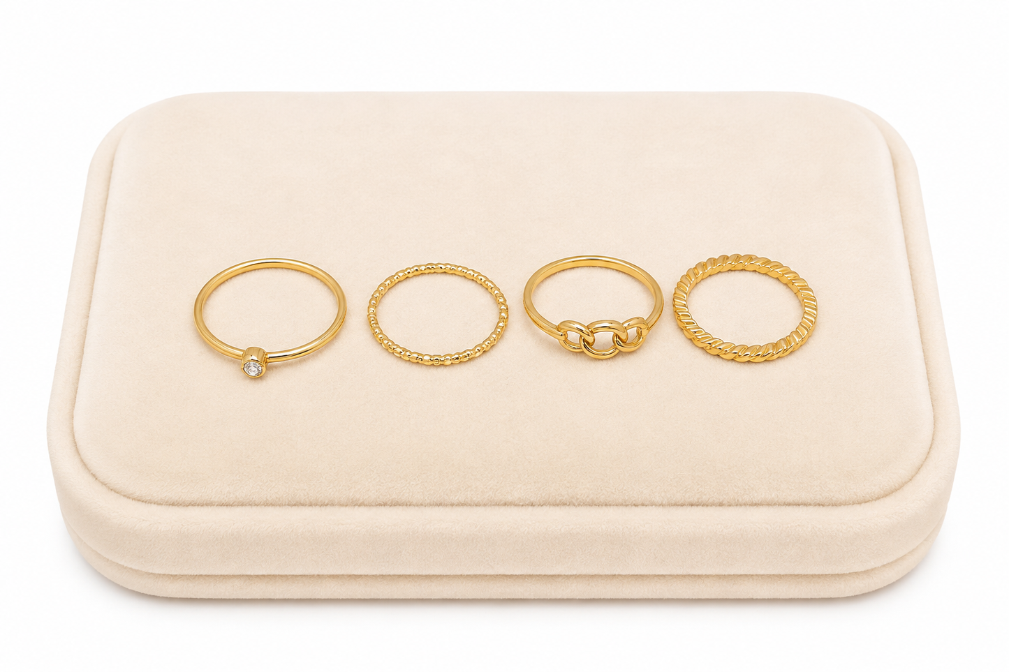 Set de 4 anillos dorados con diseños texturizados, entrelazados y piedra decorativa.