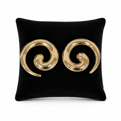 Aretes grandes dorados con diseño de espiral abierta.
