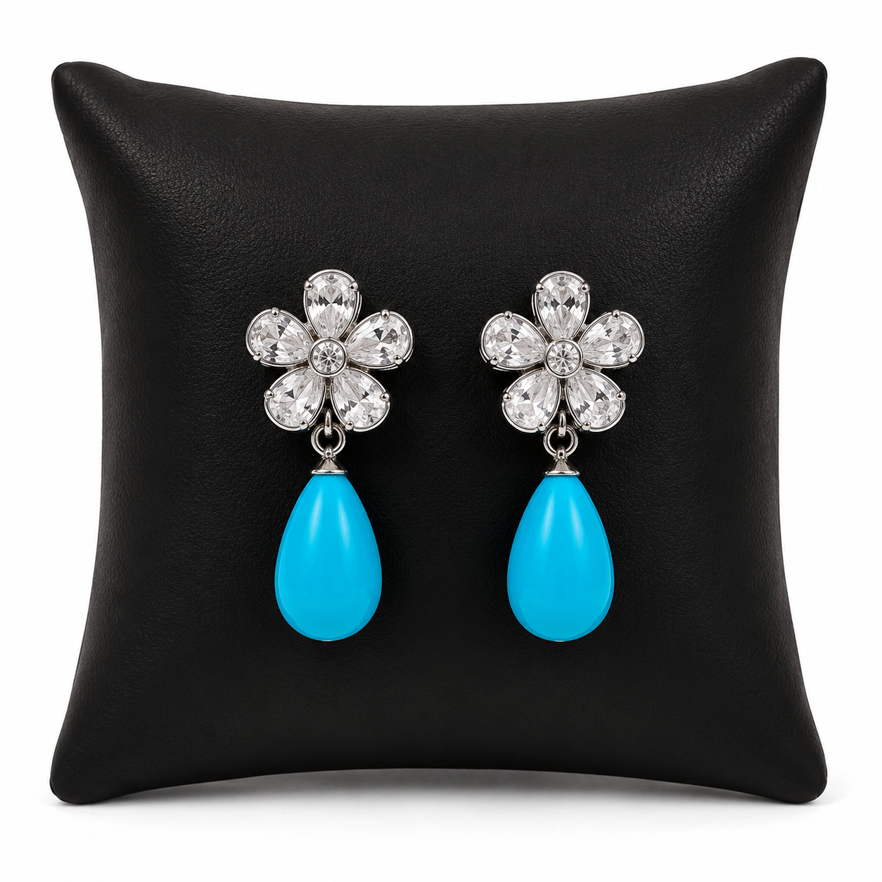 Aretes colgantes plateados con piedras turquesa en forma de gota.